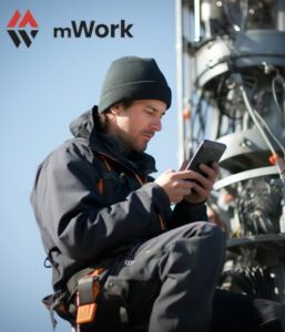En man i arbetskläder ute på jobb kollar arbetsordern i mobilen